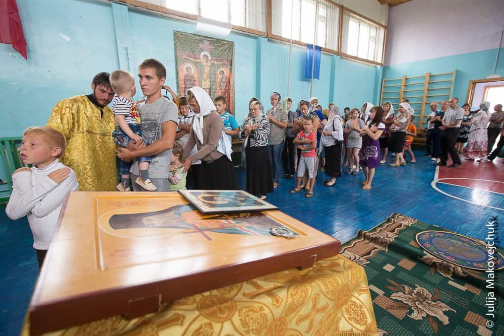 Сорок три новокрещеных христианина стоят в очереди к Чаше. В село Макарово мы прибыли вечером, время терять не стали и провели встречу-знакомство с жителями. На следующий день рано утром было крещение, а после отслужена литургия в самом большом помещении — спортивном зале школы-интерната